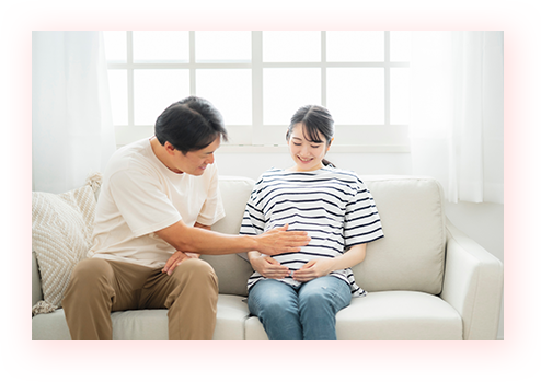 大きくなった妊婦さんのお腹をさすっている夫